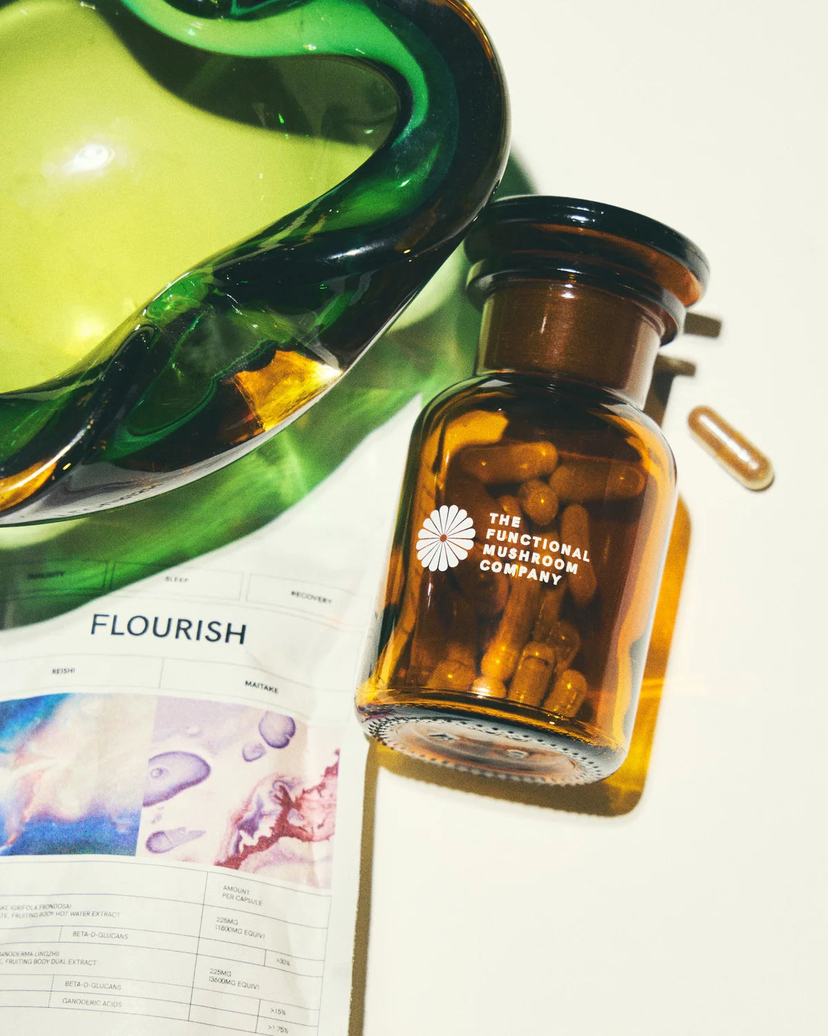 Brown bottle with 'The Functional Mushroom Company' label on a magazine with visible text and graphics.
