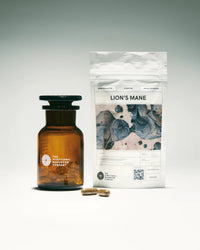 Amber glass bottle, packaging labeled 'Lion's Mane', and capsules on a gray background