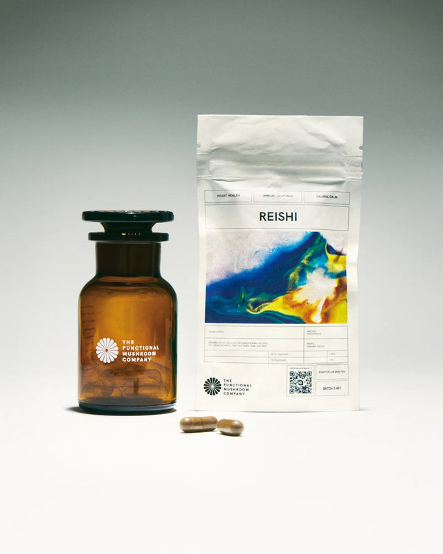 Amber bottle and Reishi supplement packaging on a gray background