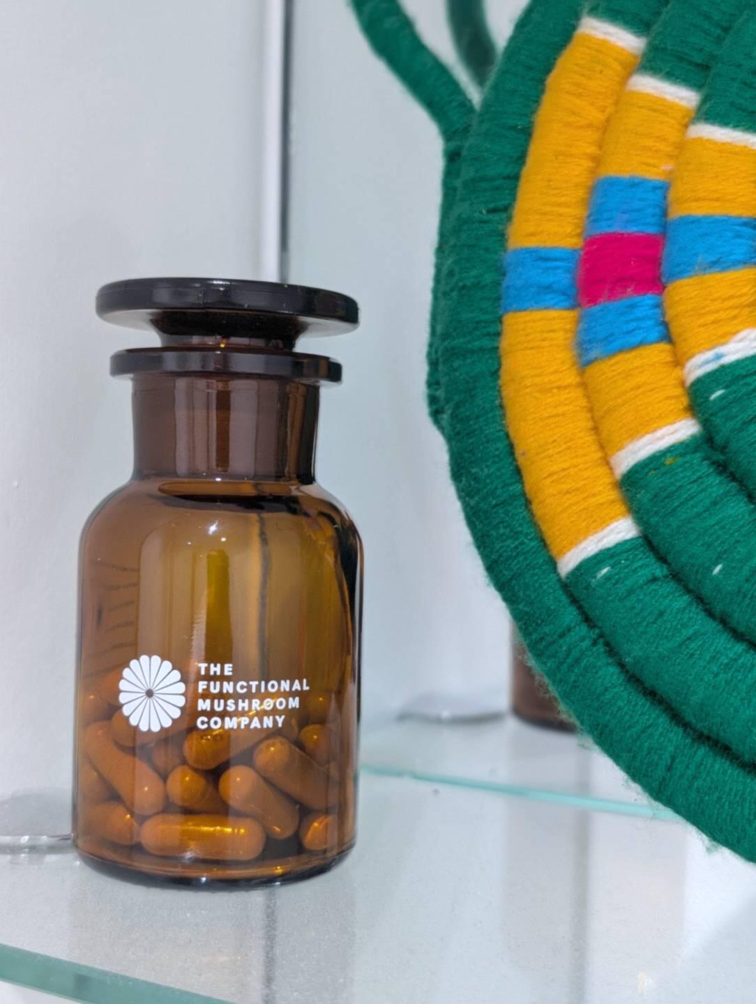 Cordyceps jar beside a woven basket, photographed by Val Delaney