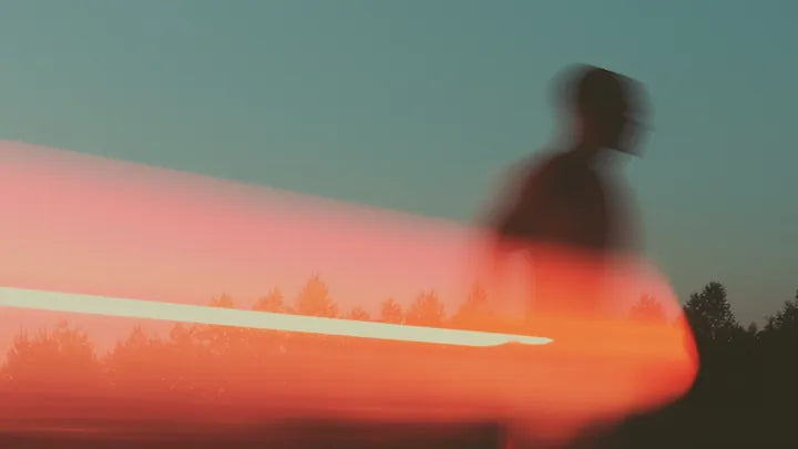 A runner in silhouette against a low sun, motion drawn out into a streak of light.